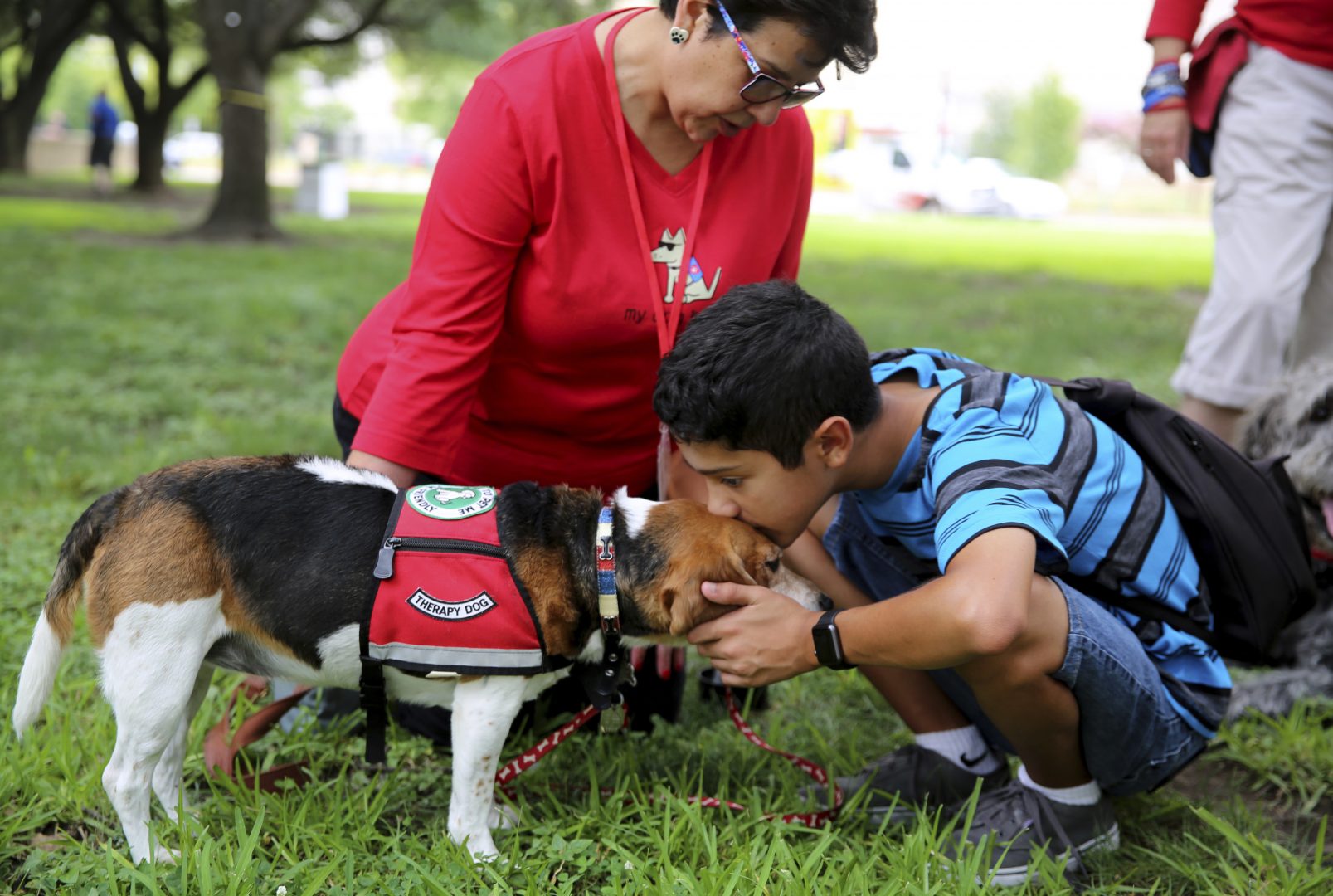 FILE PHOTO: Sammy Garza, right, kisses a therapy dog, Molly, while mother, Del Garza, looks on in downtown Dallas on Friday, July 7, 2017.