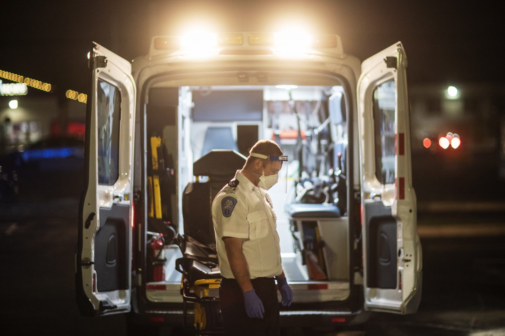 FILE PHOTO: An EMT pauses for a moment while loading a stretcher back into an ambulance after dropping off a patient at a newly opened field hospital operated by Care New England to handle a surge of COVID-19 patients in Cranston, R.I, Tuesday, Dec. 1, 2020. Nearby, Kent Hospital was using all its beds for its sickest COVID-19 patients, and needed somewhere for the overflow.