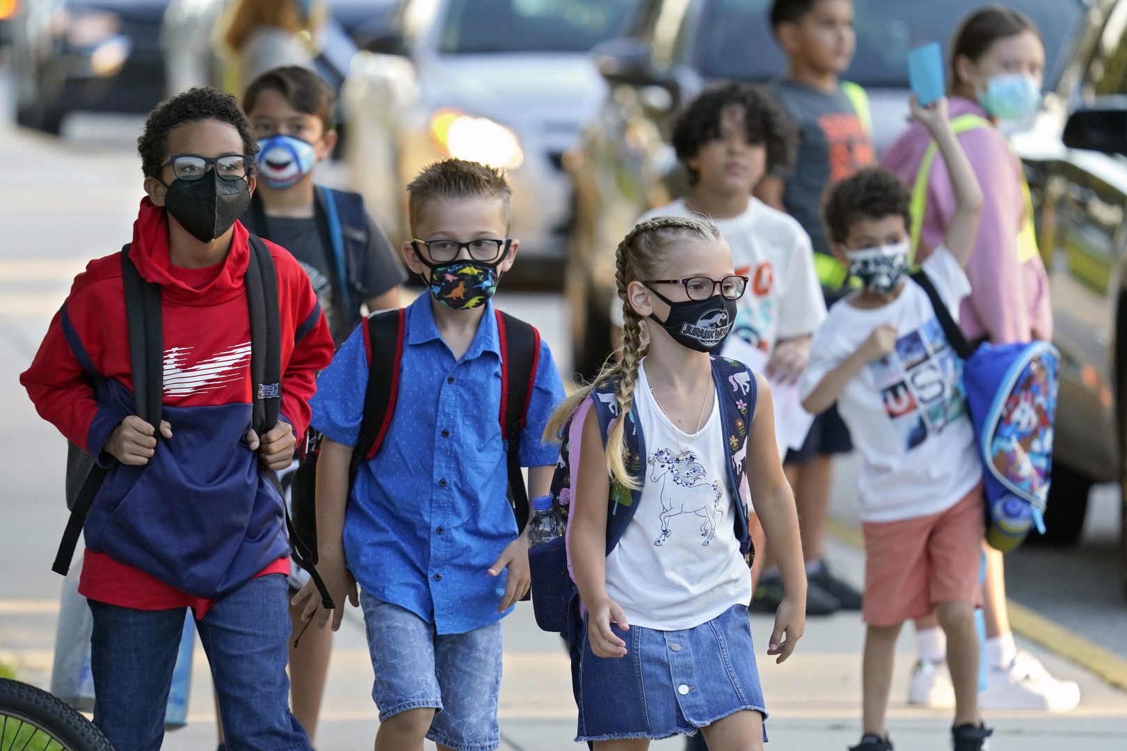 FILE PHOTO: In this Tuesday, Aug. 10, 2021, file photo, students, some wearing protective masks, arrive for the first day of school at Sessums Elementary School in Riverview, Fla.