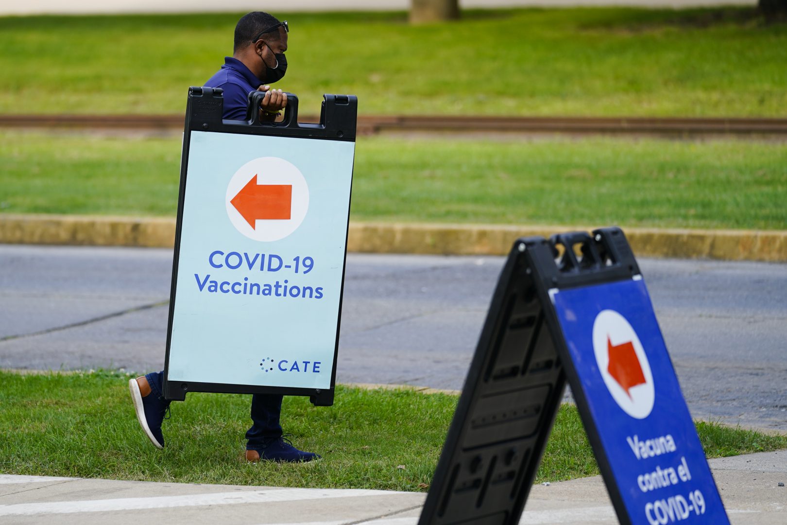 A worker posts placard for a COVID-19 vaccination clinic at the Reading Area Community College in Reading, Pa., Tuesday, Sept. 14, 2021.