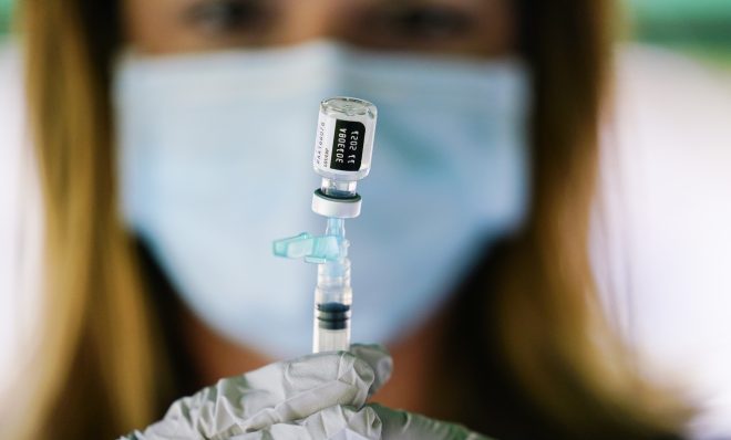 A worker prepares a syringe with the Pfizer COVID-19 vaccine at a clinic at the Reading Area Community College in Reading, Pa.