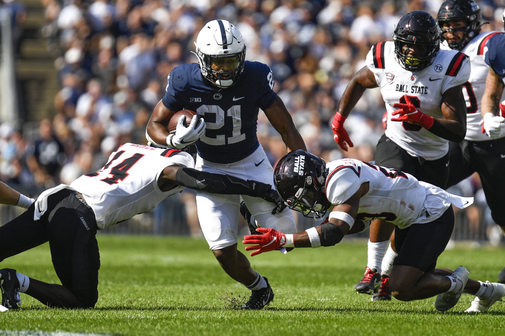 Penn State running back Noah Cain (21) splits two Ball State defenders on a first half run during an NCAA college football game in State College, Pa., on Saturday, Sept. 11, 2021. 