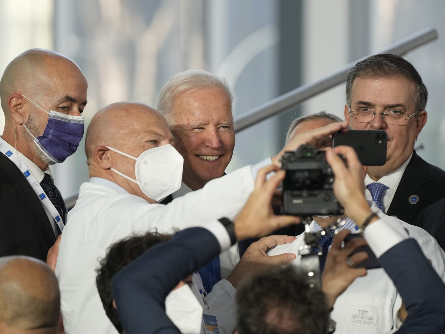 U.S. President Joe Biden poses for a selfie with medical personnel and other world leaders during a group photo at the La Nuvola conference center for the G20 summit in Rome, Saturday, Oct. 30, 2021. The two-day Group of 20 summit is the first in-person gathering of leaders of the world's biggest economies since the COVID-19 pandemic started. (AP Photo/Gregorio Borgia)