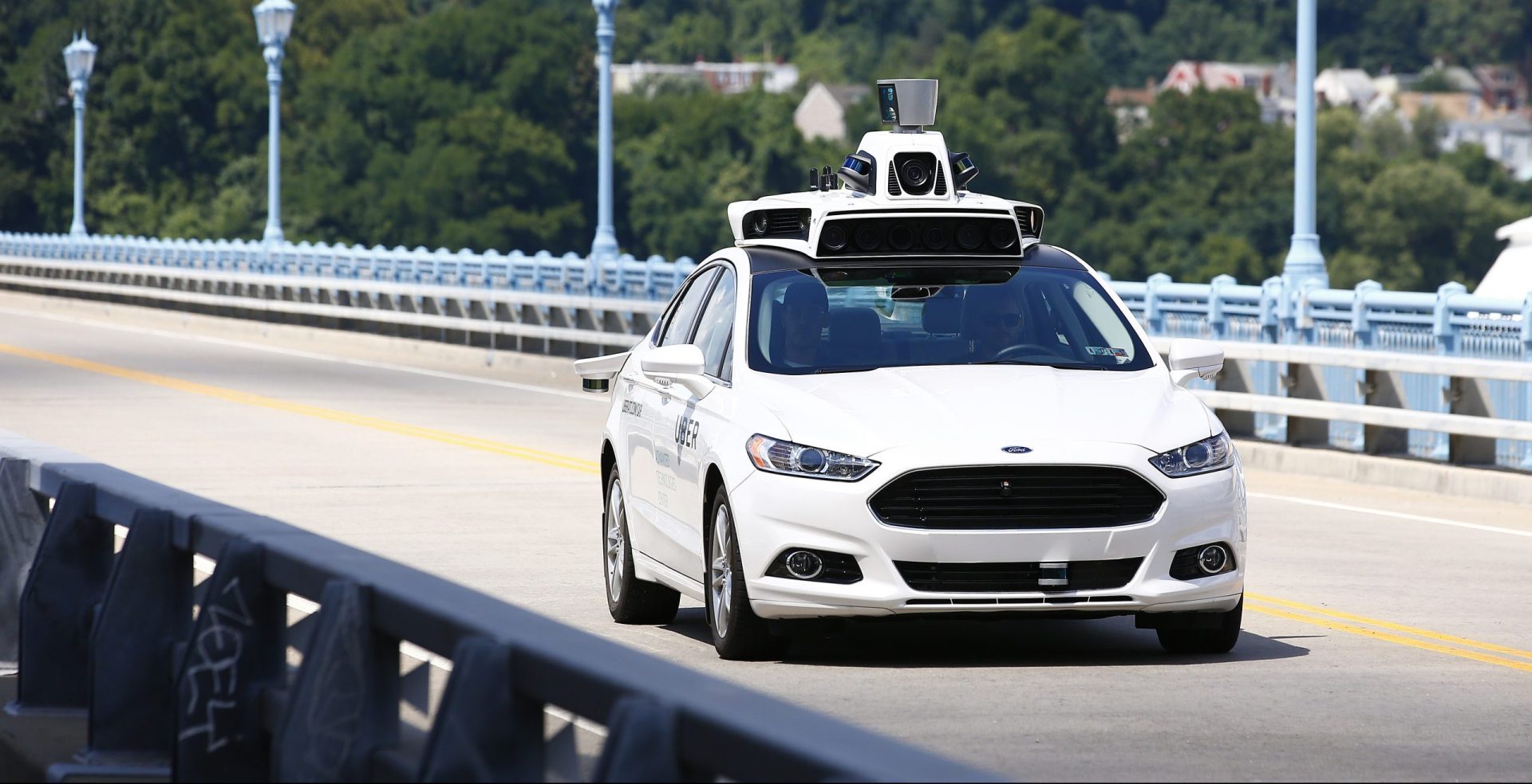 In this Thursday, Aug. 18, 2016, file photo, Uber employees test a self-driving Ford Fusion hybrid car, in Pittsburgh. After taking millions of factory jobs, robots could be coming for a new class of worker: people who drive for a living. 