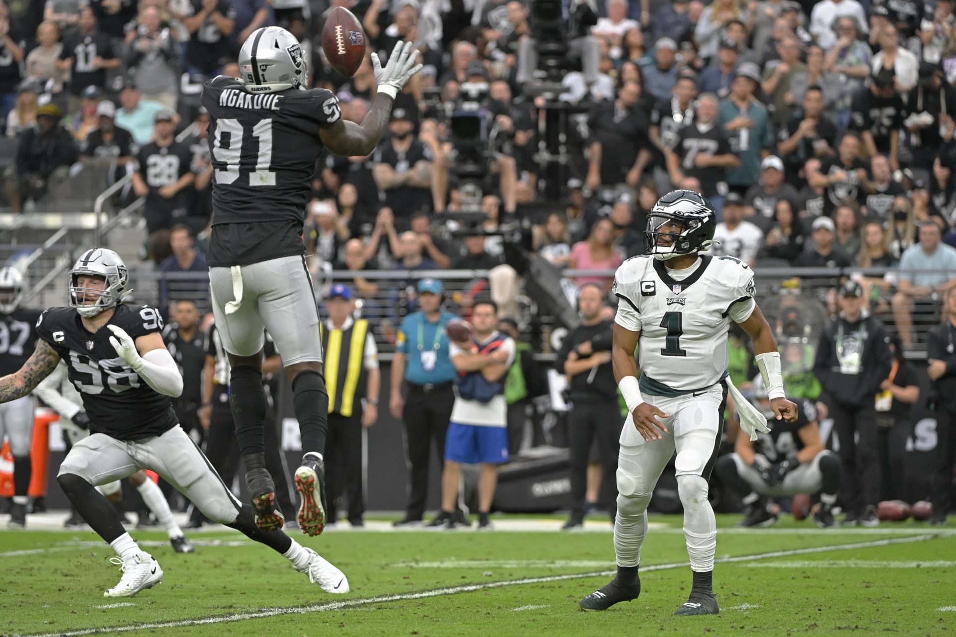 Las Vegas Raiders defensive end Yannick Ngakoue (91) blocks an attempted pass by Philadelphia Eagles quarterback Jalen Hurts (1) during the first half of an NFL football game, Sunday, Oct. 24, 2021, in Las Vegas.