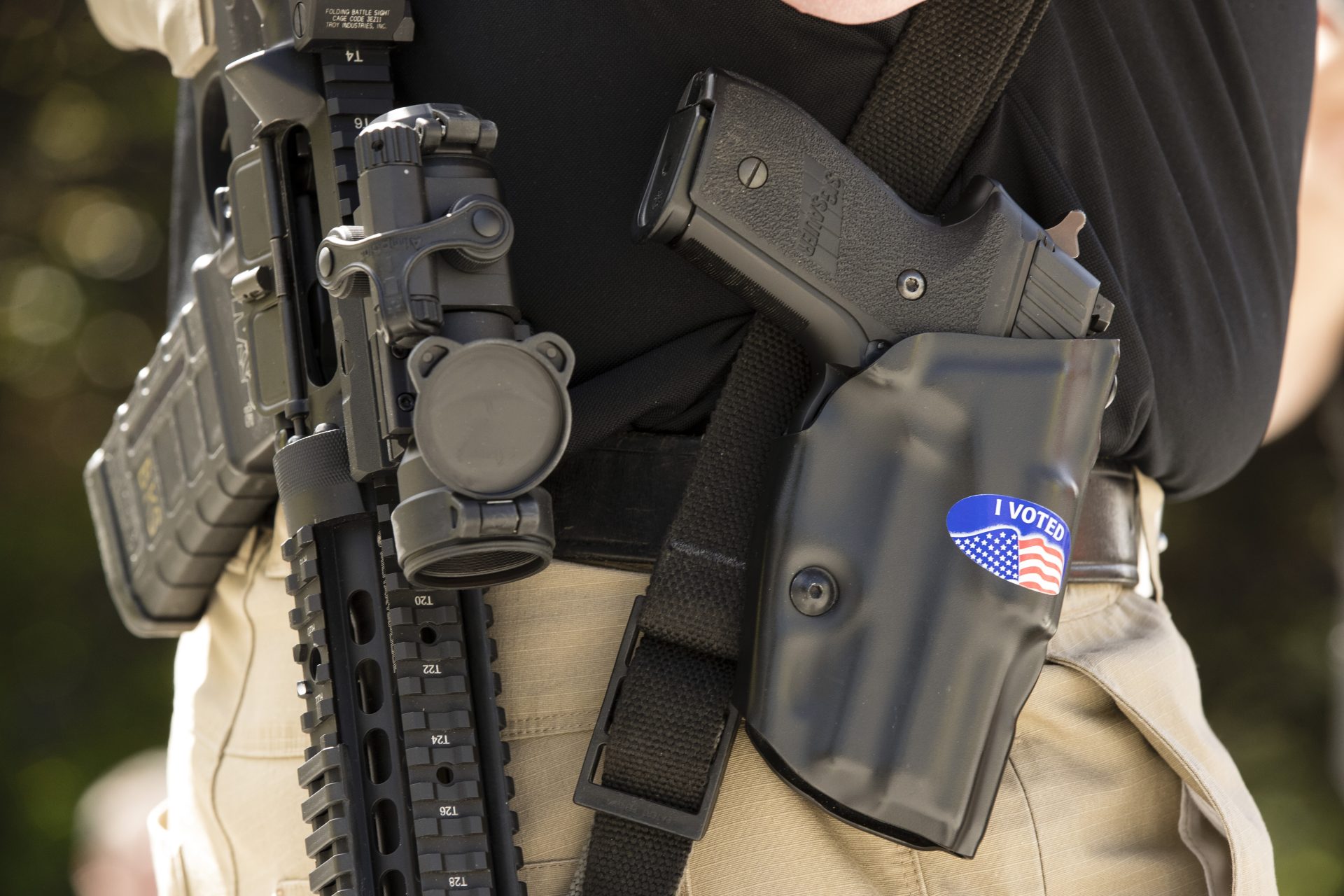 In this May 6, 2019 file photo, a gun rights advocate with an "I VOTED" sticker on his holster gathers with others for an annual rally on the steps of the state Capitol in Harrisburg, Pa.