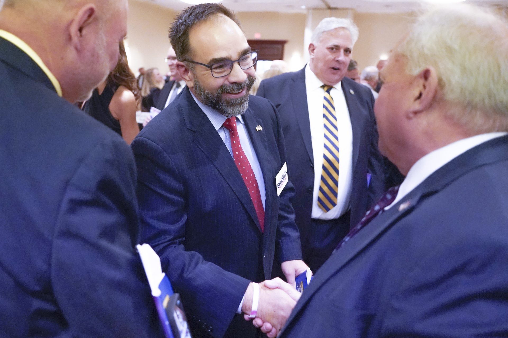 In this photo made on Friday, Oct. 22, 2021, Judge Kevin Brobson, center, greets people after attending the Amen Corner luncheon in Pittsburgh.