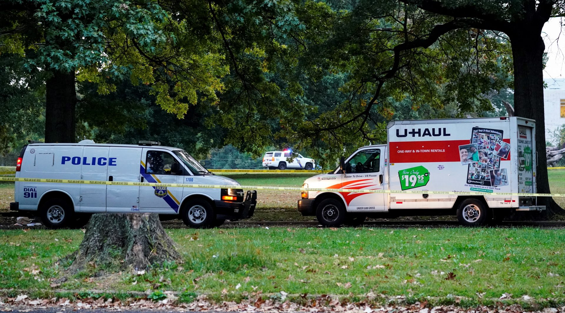 Police vehicles and a U-Haul truck are shown at a crime scene in Philadelphia, Monday, Oct. 4, 2021. Police in Philadelphia say a nurse fatally shot his co-worker at a hospital, fled the scene and was shot in a gunfight with police that wounded two officers. After the shooting, the gunman left the hospital in a U-Haul box truck. A short time later, four officers were alerted to the suspect's location by a passerby near a school.