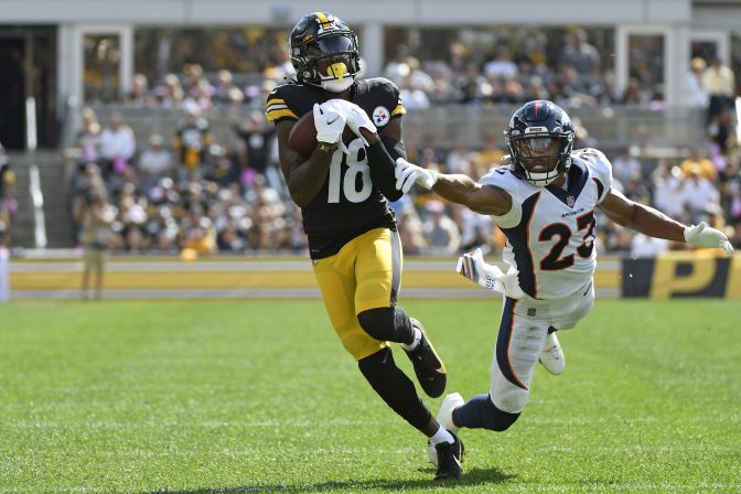 Pittsburgh Steelers wide receiver Diontae Johnson (18) hauls in a pass from quarterback Ben Roethlisberger with Denver Broncos cornerback Kyle Fuller (23) defending during the first half of an NFL football game against the Denver Broncos in Pittsburgh, Sunday, Oct. 10, 2021. Johnson took the ball in for a touchdown.