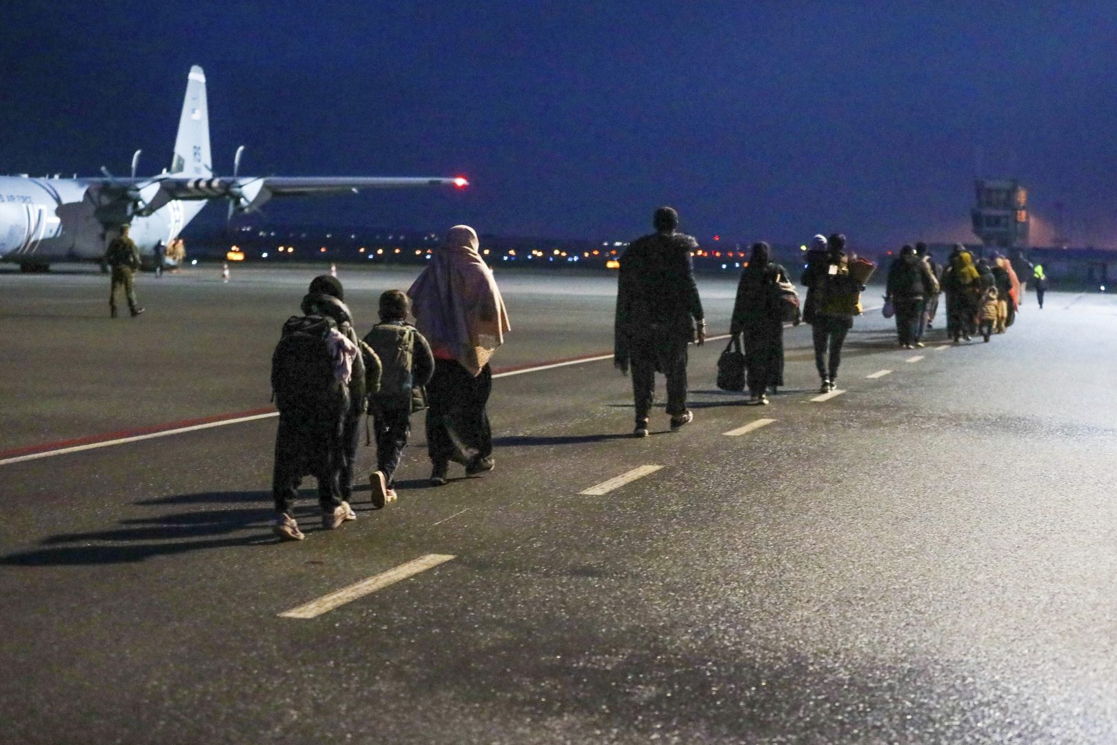 In this image provided by the U.S. Army U.S.-affiliated Afghans depart Pristina International Airport in Pristina, Kosovo on Oct. 16, 2021. During their temporary stay at Camp Liya, Afghan families receive housing, medical, and logistical support from Task Force Ever Vigilant. The U.S. is welcoming tens of thousands of Afghans airlifted out of Kabul but has disclosed little publicly about a small group who remain overseas: Dozens who triggered potential security issues during security vetting and have been sent to an American base in the Balkan nation of Kosovo. The exact number in Kosovo fluctuates as new people arrive and others leave when security issues, such as missing documents, are resolved, according to U.S. officials.  (Sgt. Gloria Kamencik/U.S. Army via AP)