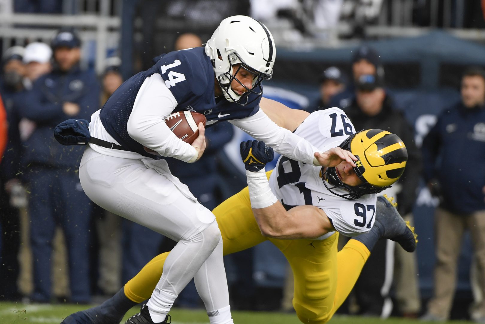 Michigan defensive end Aidan Hutchinson (97) tackles Penn State quarterback Sean Clifford (14) in the first quarter of an NCAA college football game in State College, Pa., Saturday, Nov. 13, 2021. (AP Photo/Barry Reeger)