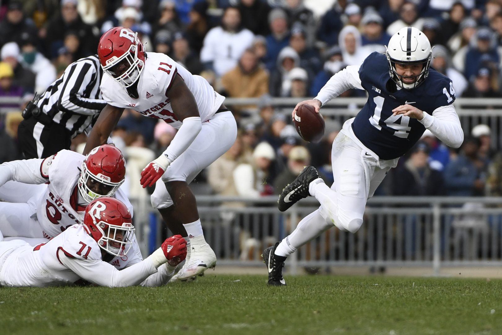 Rutgers defensive lineman Aaron Lewis (71) tries to tackle Penn State quarterback Sean Clifford (14) during the first half of an NCAA college football game in State College, Pa., Saturday, Nov. 20, 2021. (AP Photo/Barry Reeger)