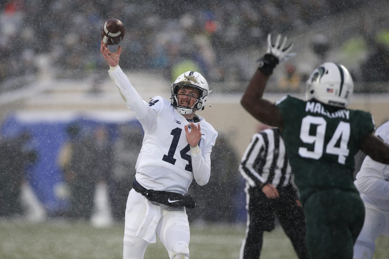 Penn State quarterback Sean Clifford, left, throws a pass for a touchdown against Michigan State's Dashaun Mallory (94) during the first quarter of an NCAA college football game, Saturday, Nov. 27, 2021, in East Lansing, Mich. (AP Photo/Al Goldis)