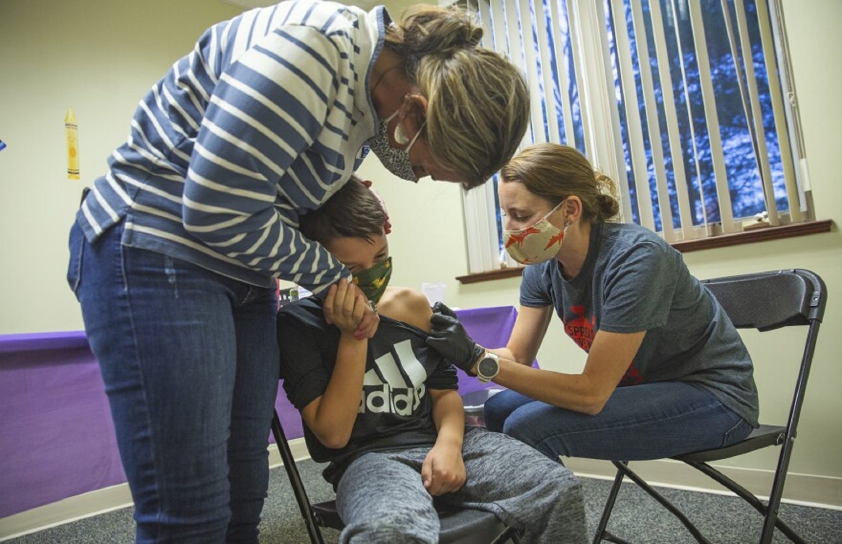 Seven-year-old Levi Hockenberry, middle, gets his COVID-19 vaccine during a clinic hosted by Centre Volunteers in Medicine on Tuesday, November 9, 2021.
