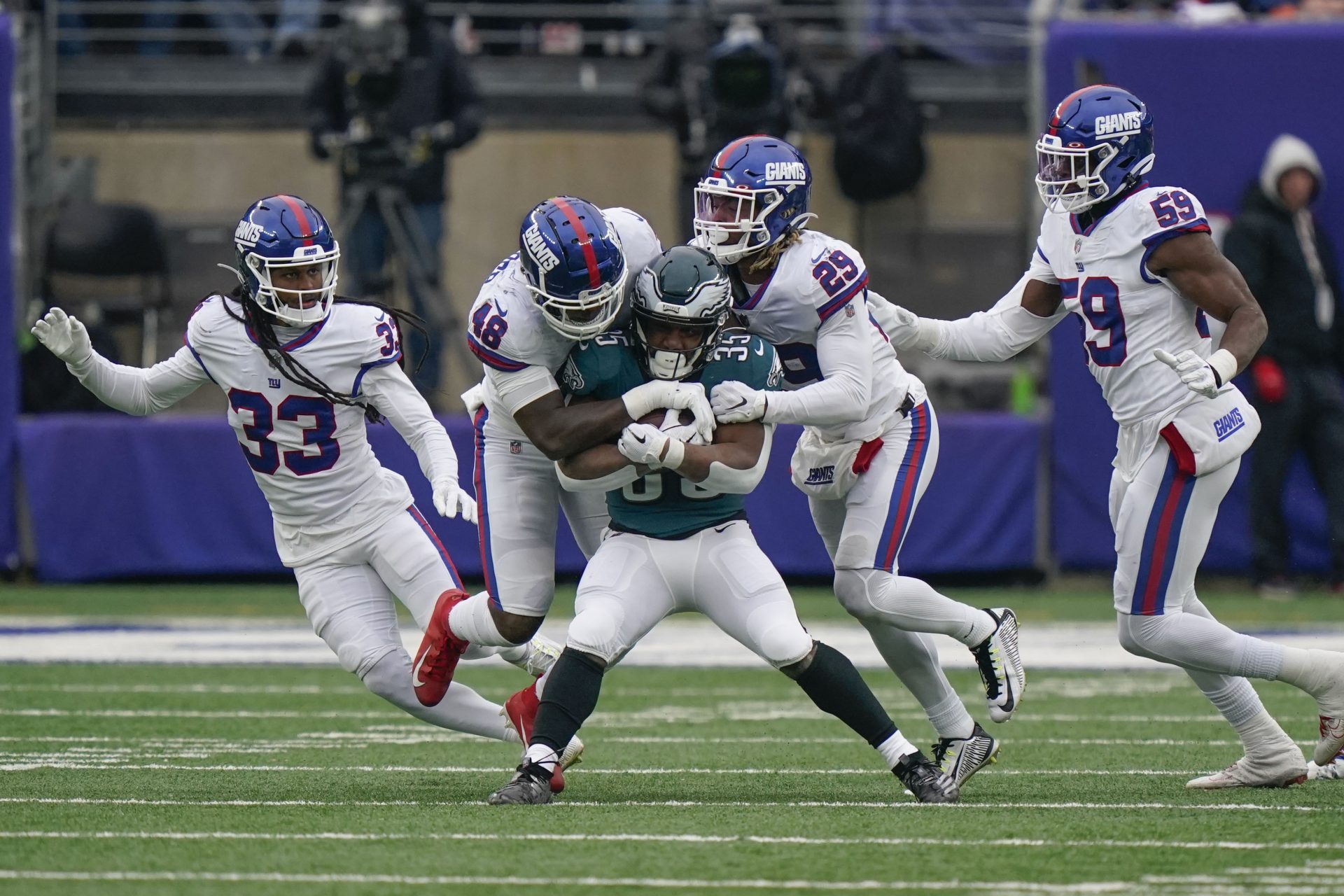 New York Giants defenders tackle Philadelphia Eagles' Boston Scott, center, during the first half of an NFL football game, Sunday, Nov. 28, 2021, in East Rutherford, N.J.