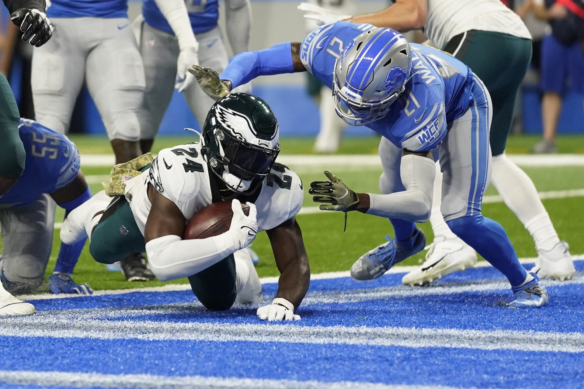 Philadelphia Eagles running back Jordan Howard (24) falls into the end zone for a 4-yard touchdown run as Detroit Lions free safety Tracy Walker III (21) defends during the first half of an NFL football game, Sunday, Oct. 31, 2021, in Detroit.