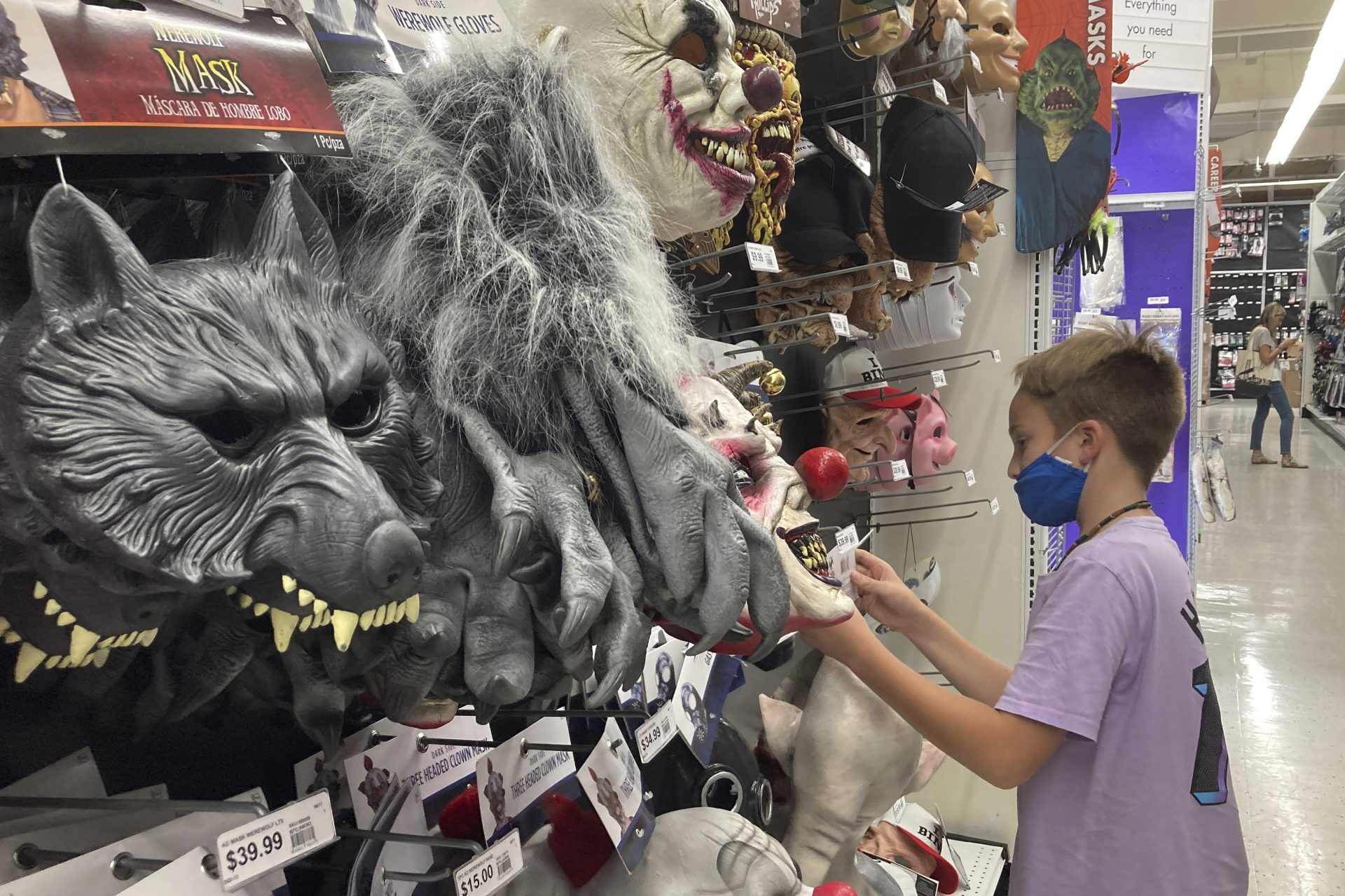 A young customer looks at a Halloween mask at a Party City store, Oct. 6, 2021, in Miami. Prices for U.S. consumers jumped 6.2% in October compared with a year earlier as surging costs for food, gas and housing left Americans grappling with the highest inflation rate since 1990.