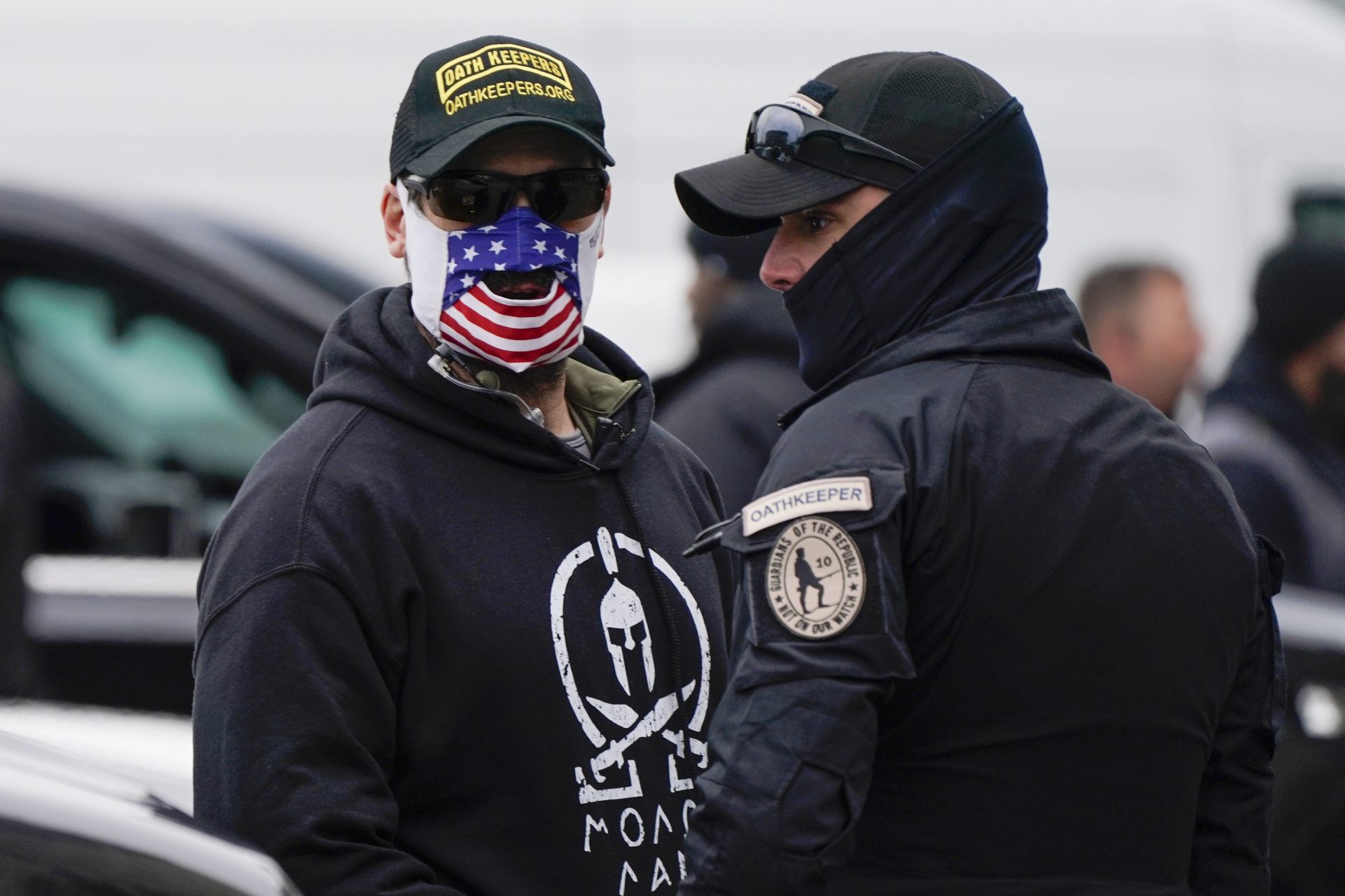 People wearing hats and patches indicating they are part of Oath Keepers attend a rally at Freedom Plaza Tuesday, Jan. 5, 2021, in Washington, in support of President Donald Trump.