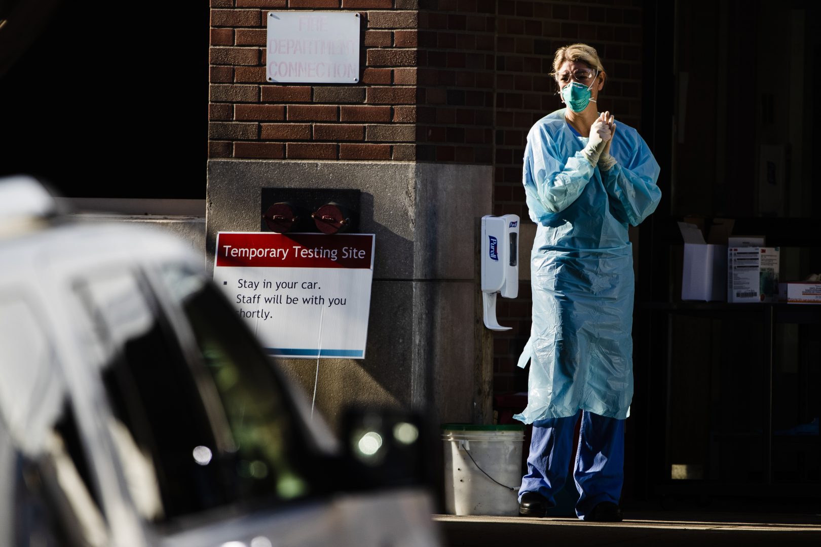 A healthcare worker stands by at a COVID-19 temporary testing site at Abington Hospital in Abington, Pa., Wednesday, March 18, 2020. For most people, the new coronavirus causes only mild or moderate symptoms. For some it can cause more severe illness. (AP Photo/Matt Rourke)