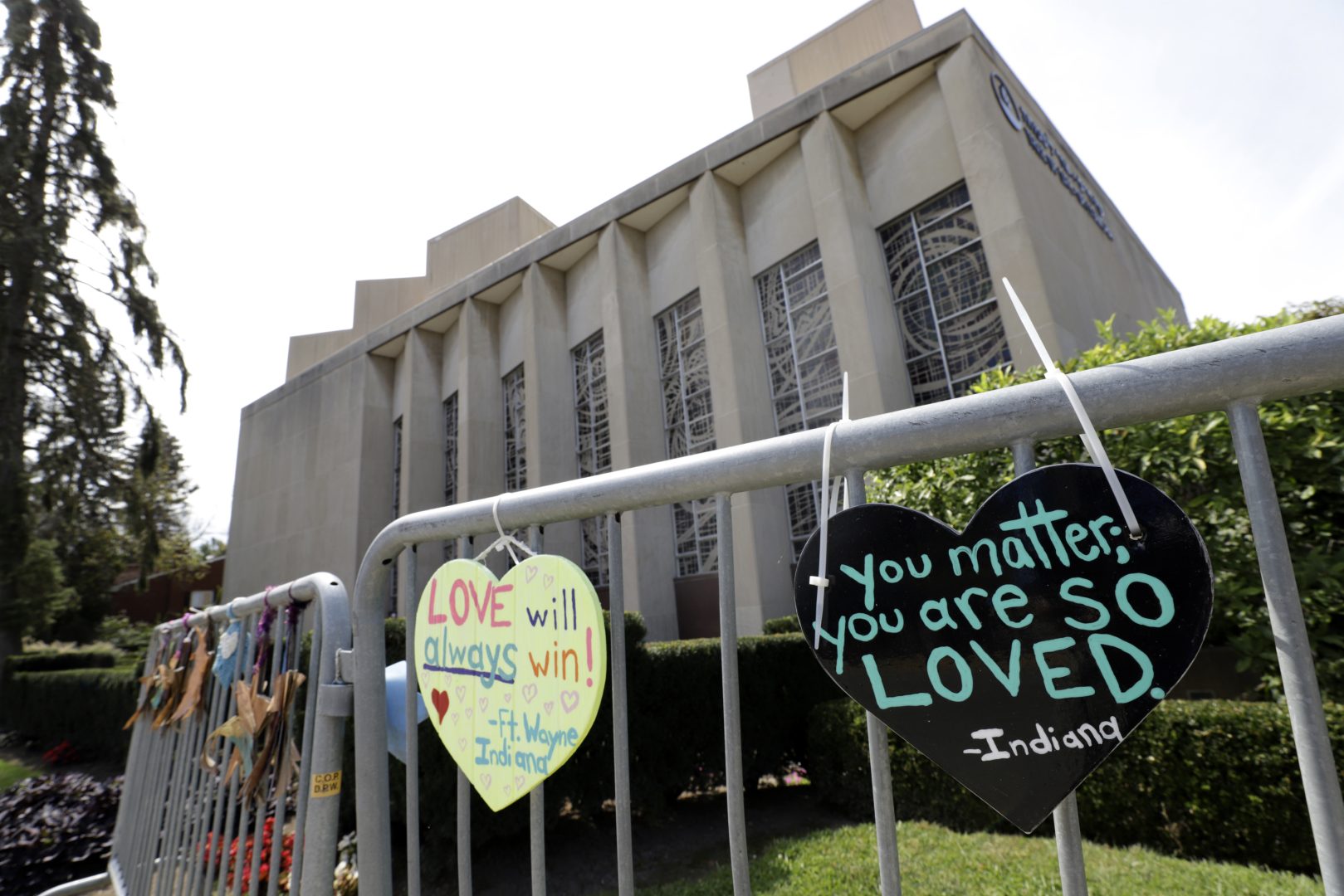 FILE - Signs hang on a fence surrounding the Tree of Life synagogue in Pittsburgh on Sept. 17, 2019.  Prosecutors told a federal judge, Thursday, Dec. 2, 2021,  in a new filing that the Pittsburgh synagogue massacre defendant’s statements at the scene should be allowed for use at trial, in part because concerns about public safety in the immediate aftermath were a valid reason to keep questioning him.  