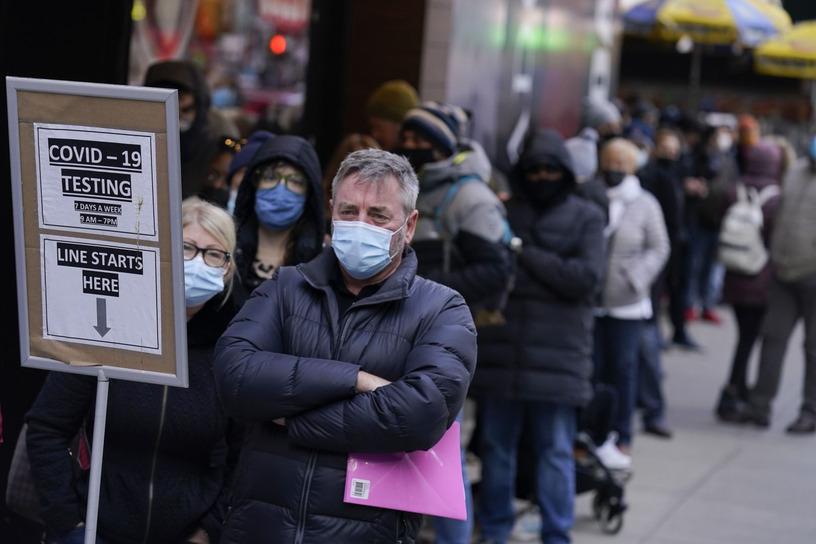 FILE - People wait in line at a COVID-19 testing site in New York' Times Square on Dec. 13, 2021. More than a year after the vaccine was rolled out, new cases of COVID-19 in the U.S. have soared to their highest level on record at over 265,000 per day on average, a surge driven largely by the highly contagious omicron variant. (AP Photo/Seth Wenig, File)