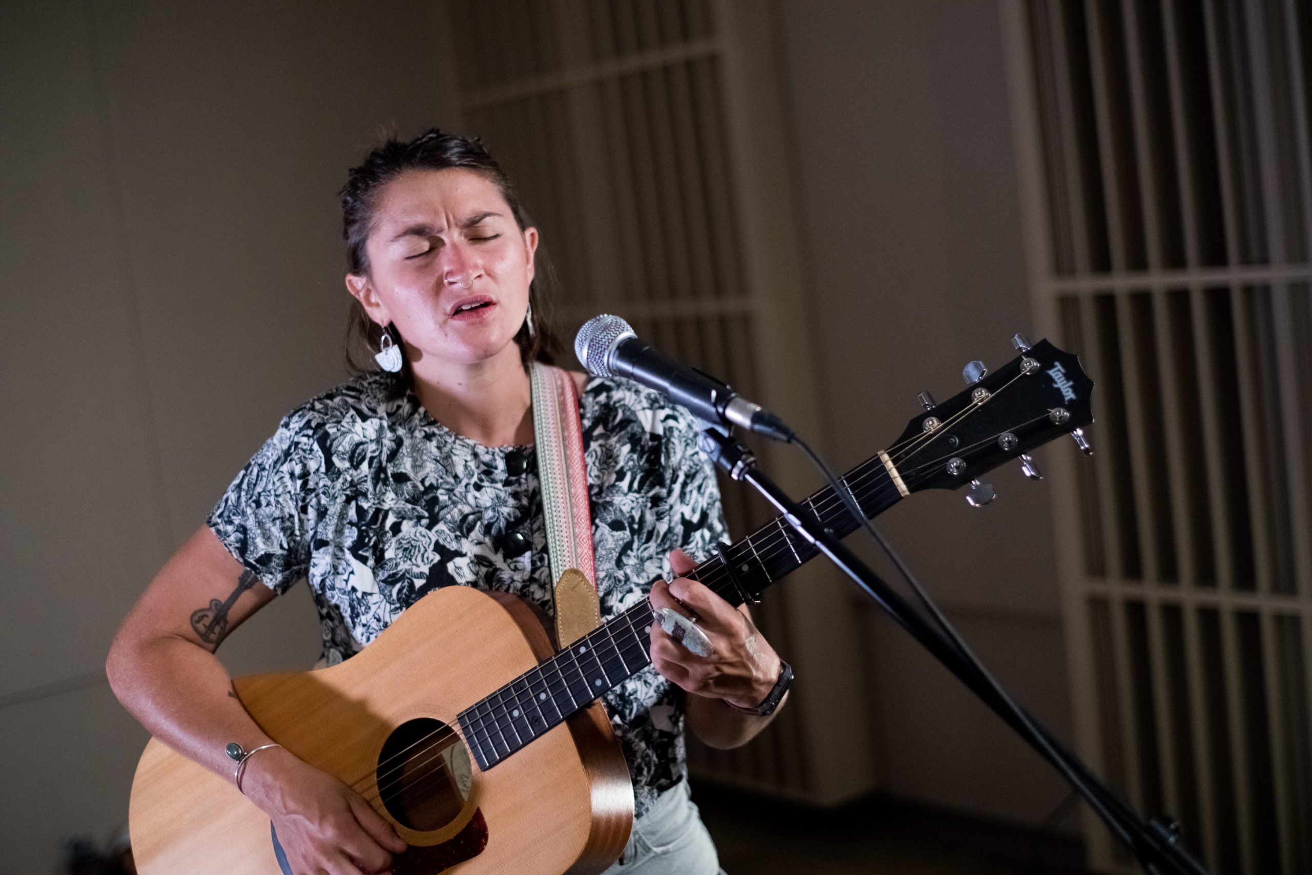 Virginia Masland playing guitar and singing.