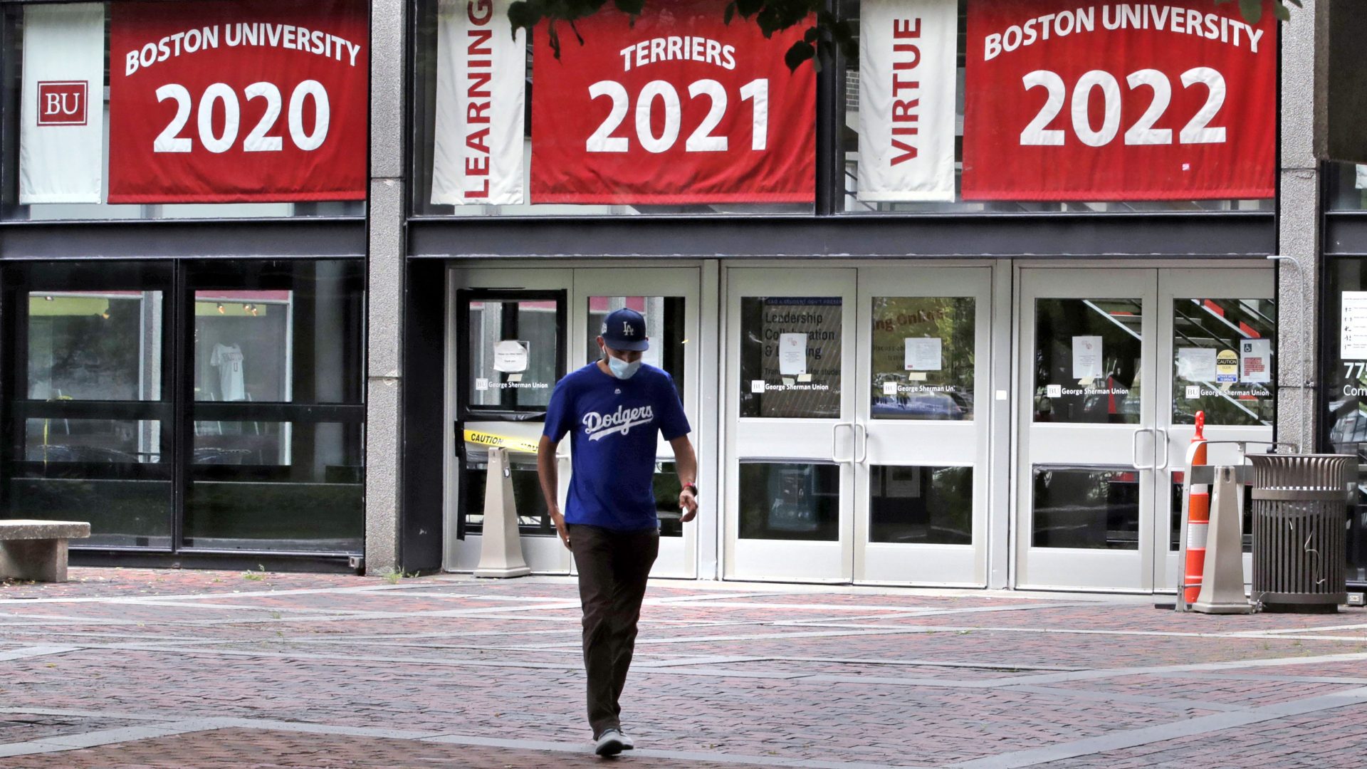 Weston Koenn, a graduate student from Los Angeles, leaves the Boston University student union building as he walks through the student-less campus in Boston, July 23, 2020.