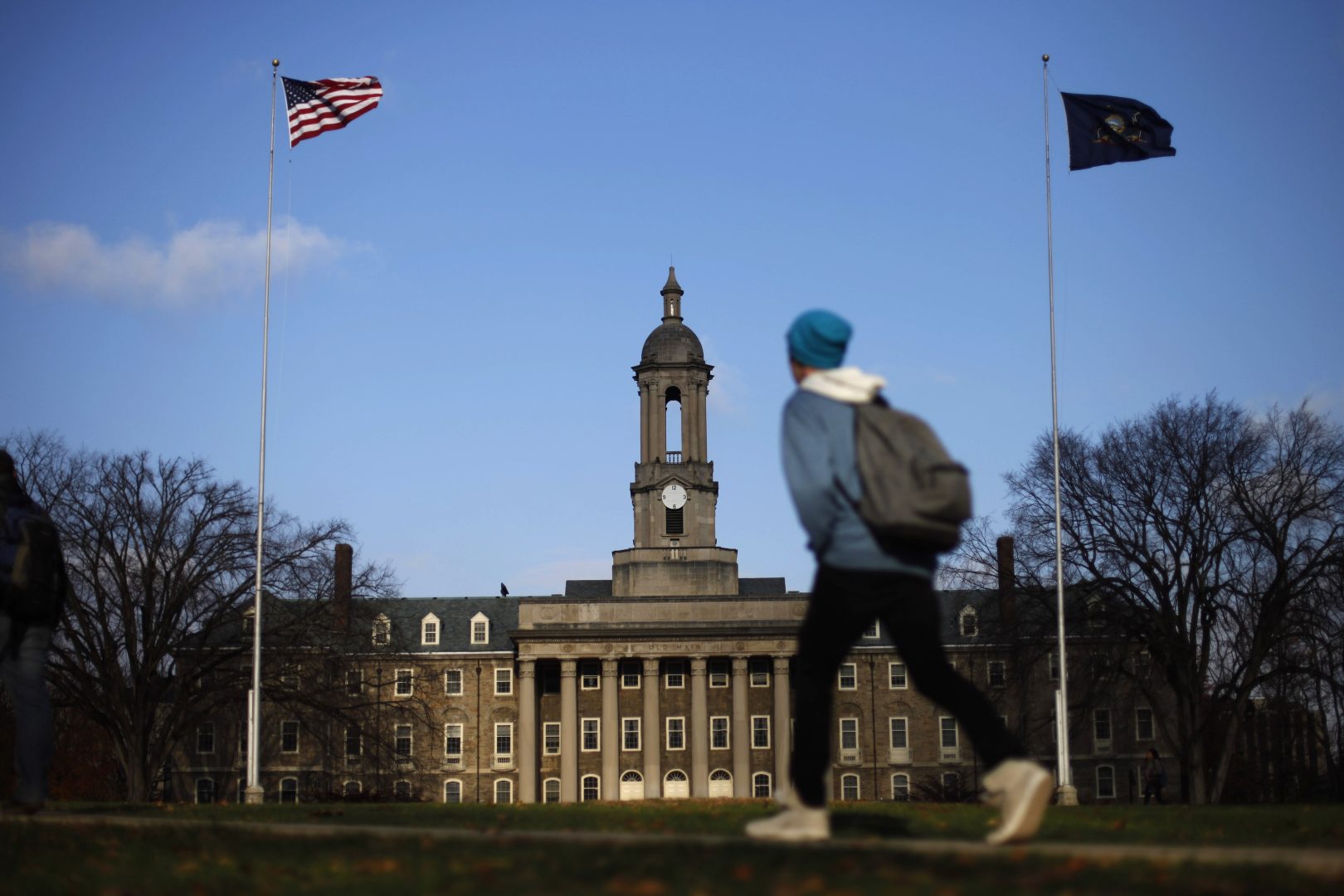 In this Friday, Nov. 11, 2011 file photo, a student walks in front of the Old Main building on the Penn State campus in State College, Pa.  