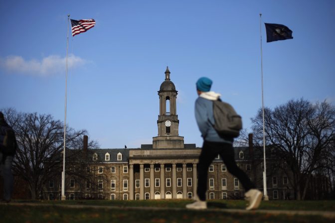 In this Friday, Nov. 11, 2011 file photo, a student walks in front of the Old Main building on the Penn State campus in State College, Pa.