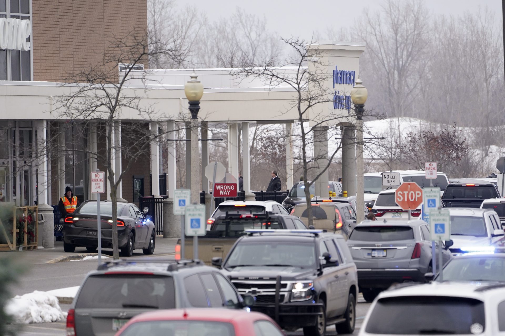 Police are shown in the parking lot of a Meijer store where Oxford High School students were being reunited with parents in Oxford, Mich., Tuesday, Nov. 30, 2021.