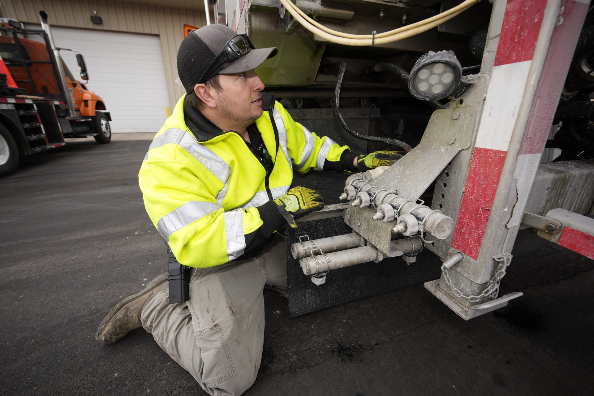 Chris Vigil checks the hoses on the material spreader as he prepares his snowplow for operation as forecasters predict the first snow of the season to sweep over Front Range communities Thursday, Dec. 9, 2021, at the Colorado Department of Transportation shed in Castle Rock, Colo.