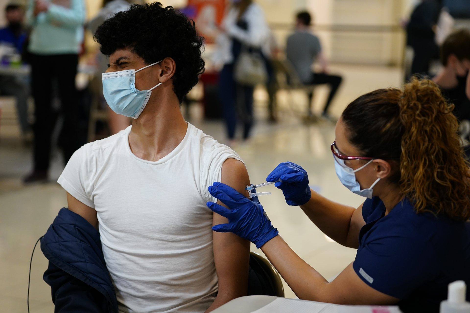 Nawaf Albarakati, 17, of Narberth, Pa., reacts as he receives a Pfizer COVID-19 vaccination from registered nurse Alicia Jimenez at a Montgomery County, Pa., Office of Public Health vaccination clinic at the King of Prussia Mall, Tuesday, May 11, 2021, in King of Prussia., Pa.