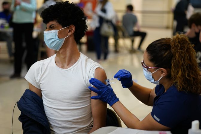 Nawaf Albarakati, 17, of Narberth, Pa., reacts as he receives a Pfizer COVID-19 vaccination from registered nurse Alicia Jimenez at a Montgomery County, Pa., Office of Public Health vaccination clinic at the King of Prussia Mall, Tuesday, May 11, 2021, in King of Prussia., Pa.