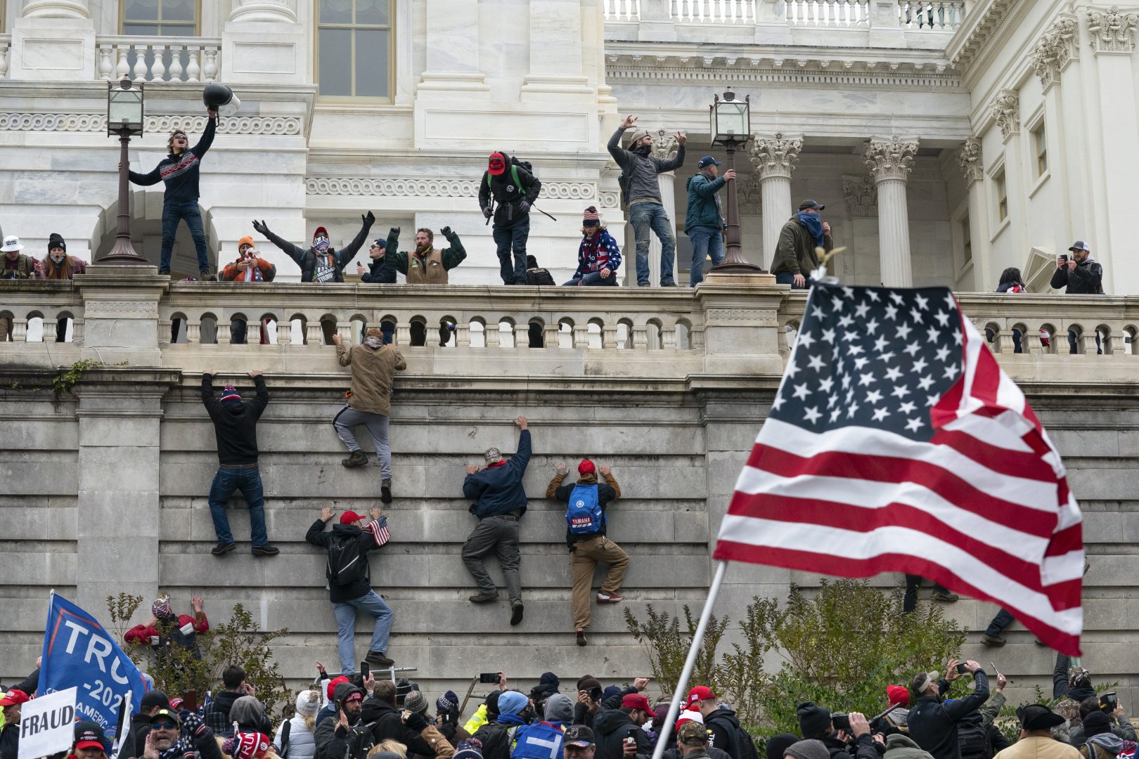 Rioters scale a wall at the U.S. Capitol on Jan. 6, 2021, in Washington. 