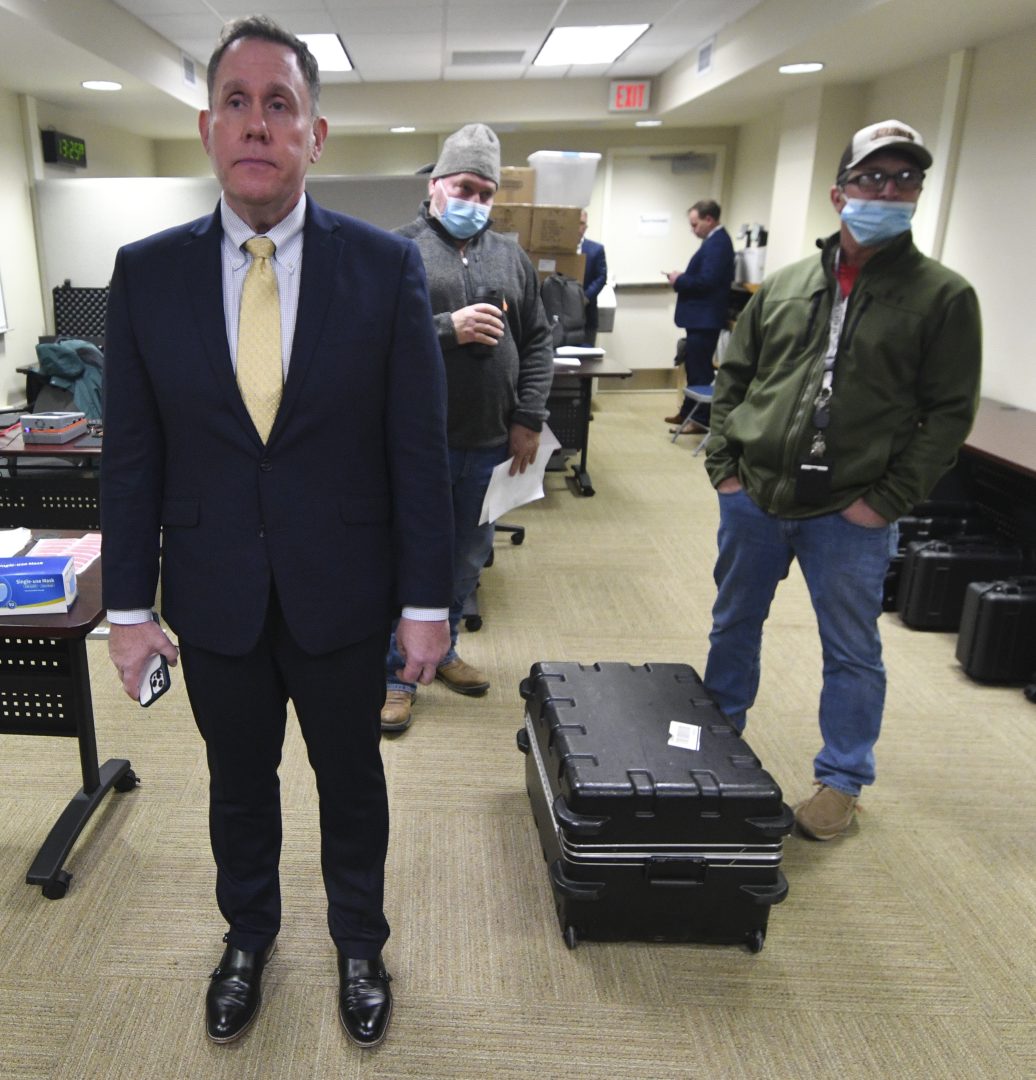 Thomas Breth, left, a lawyer for Fulton County, Pa., stands with other county officials and explains that the state Supreme Court had just put their voting machine inspection on hold before it started in McConnellsburg, Pa., Friday, Jan. 14, 2022. (AP Photo/Marc Levy)
