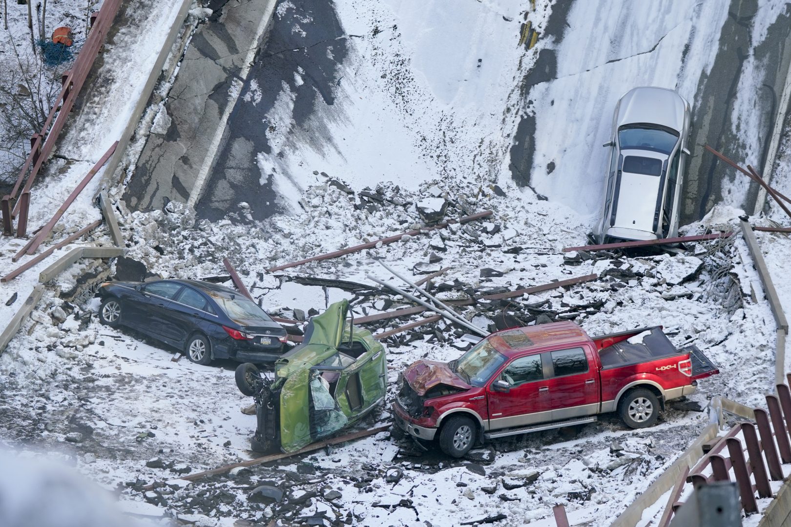 Vehicles that were on a bridge when it collapsed Friday are seen in the rubble during the recovery process on Monday, Jan. 31, 2022 in Pittsburgh's East End. (AP Photo/Gene J. Puskar)