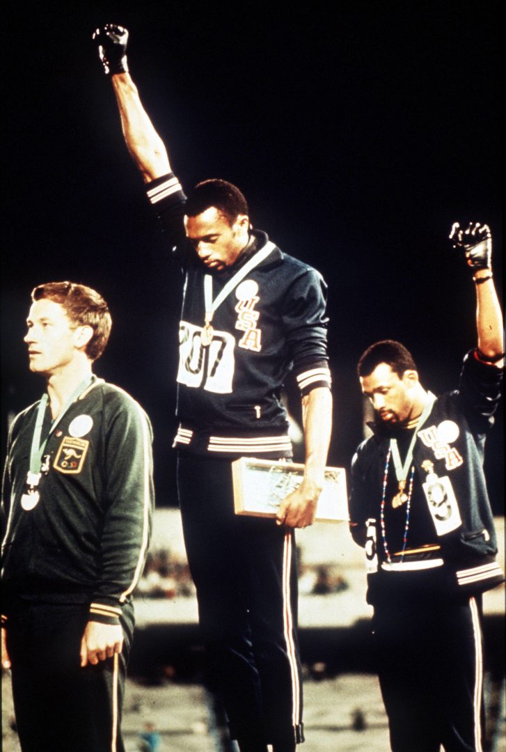 1968 Olympic Games, Mexico City, Mexico, Men's 200 Metres Final, USA gold medallist Tommie Smith (C) and bronze medallist John Carlos give the black power salutes as an anti-racial protest as they stand on the podium with Australian silver medallist Peter Norman 
