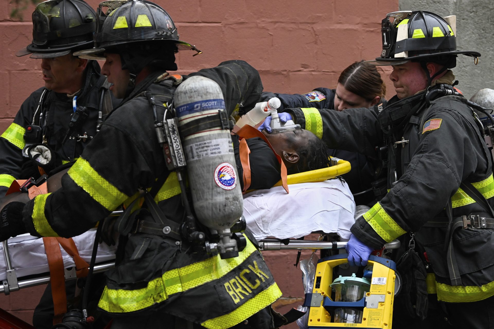 Emergency personnel use a manual resuscitator on a fire victim during a high rise fire on East 181 Street, Sunday, Jan. 9, 2022, in the Bronx borough of New York.