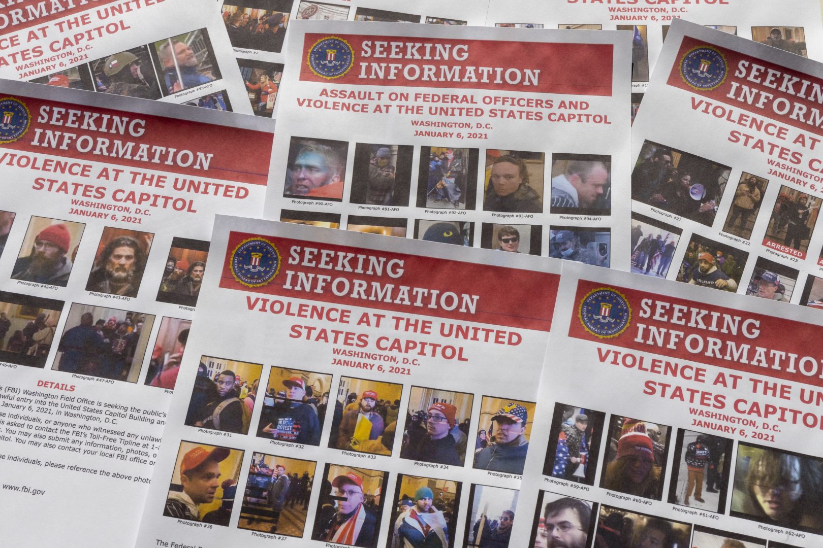 Seeking information flyers produced by the FBI are photographed on Dec. 20, 2021. The Justice Department has undertaken the largest investigation in its history with the probe into rioters who stormed the Capitol on Jan. 6. 