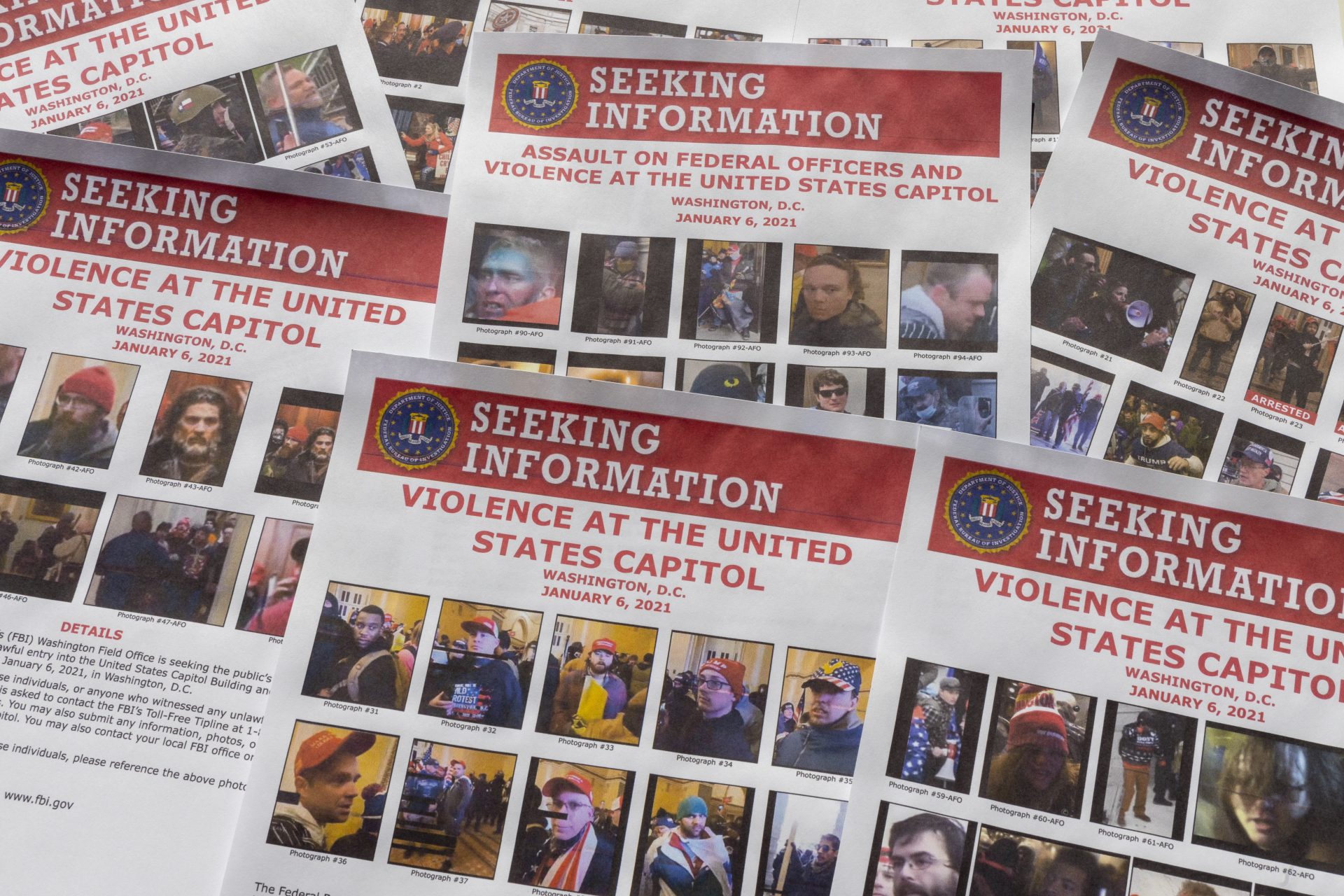 Seeking information flyers produced by the FBI are photographed on Dec. 20, 2021. The Justice Department has undertaken the largest investigation in its history with the probe into rioters who stormed the Capitol on Jan. 6.