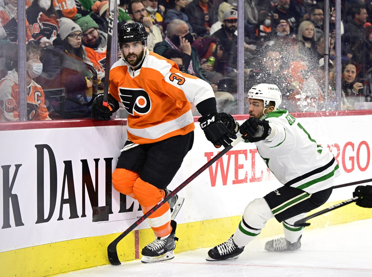 Philadelphia Flyers' Keith Yandle, left, and Dallas Stars' Luke Glendening battle along the boards during the first period of an NHL hockey game, Monday, Jan. 24, 2022, in Philadelphia. Yandle tied the NHL record for consecutive games played with 964 on Monday. 