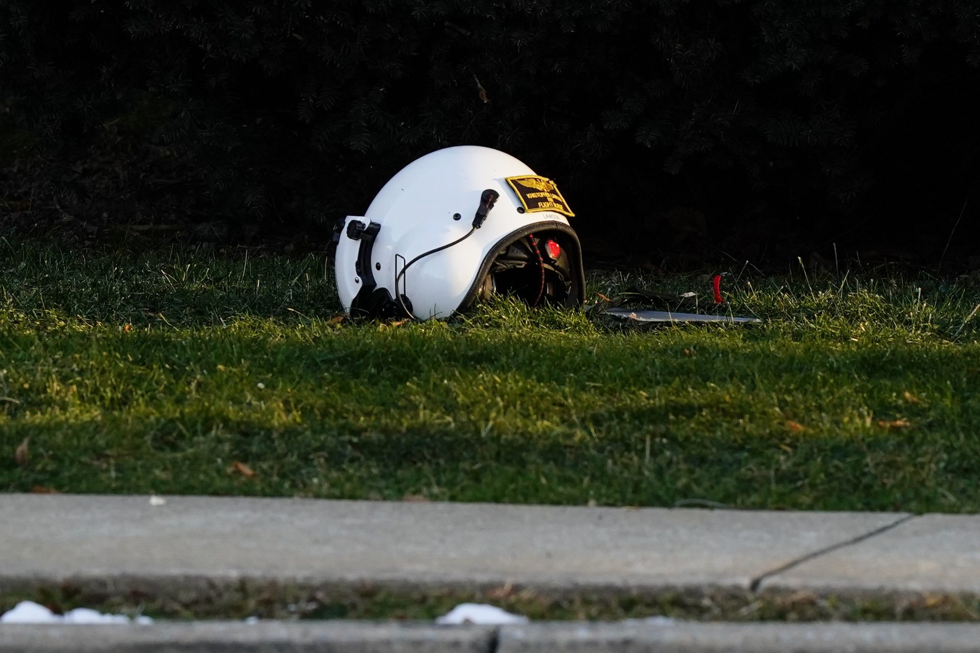 A helmet sits on the ground near the scene of a crashed medical helicopter in the Drexel Hill section of Upper Darby, Pa., on Tuesday, Jan. 11, 2022.