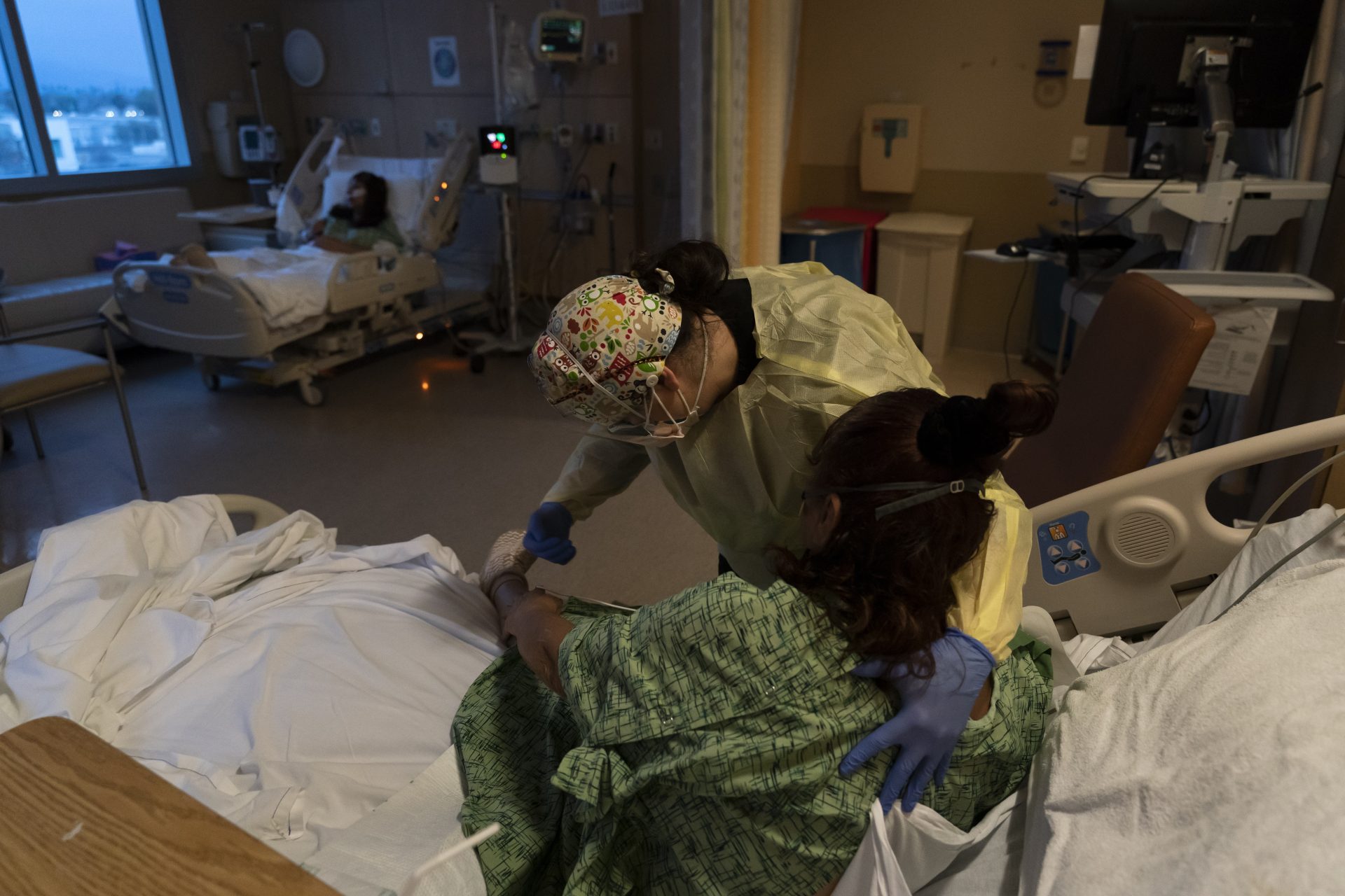 Registered nurse Nvard Termendzhyan helps Linda Calderon, a 71-year-old COVID-19 patient, sit up at Providence Holy Cross Medical Center in Los Angeles, Dec. 13, 2021.