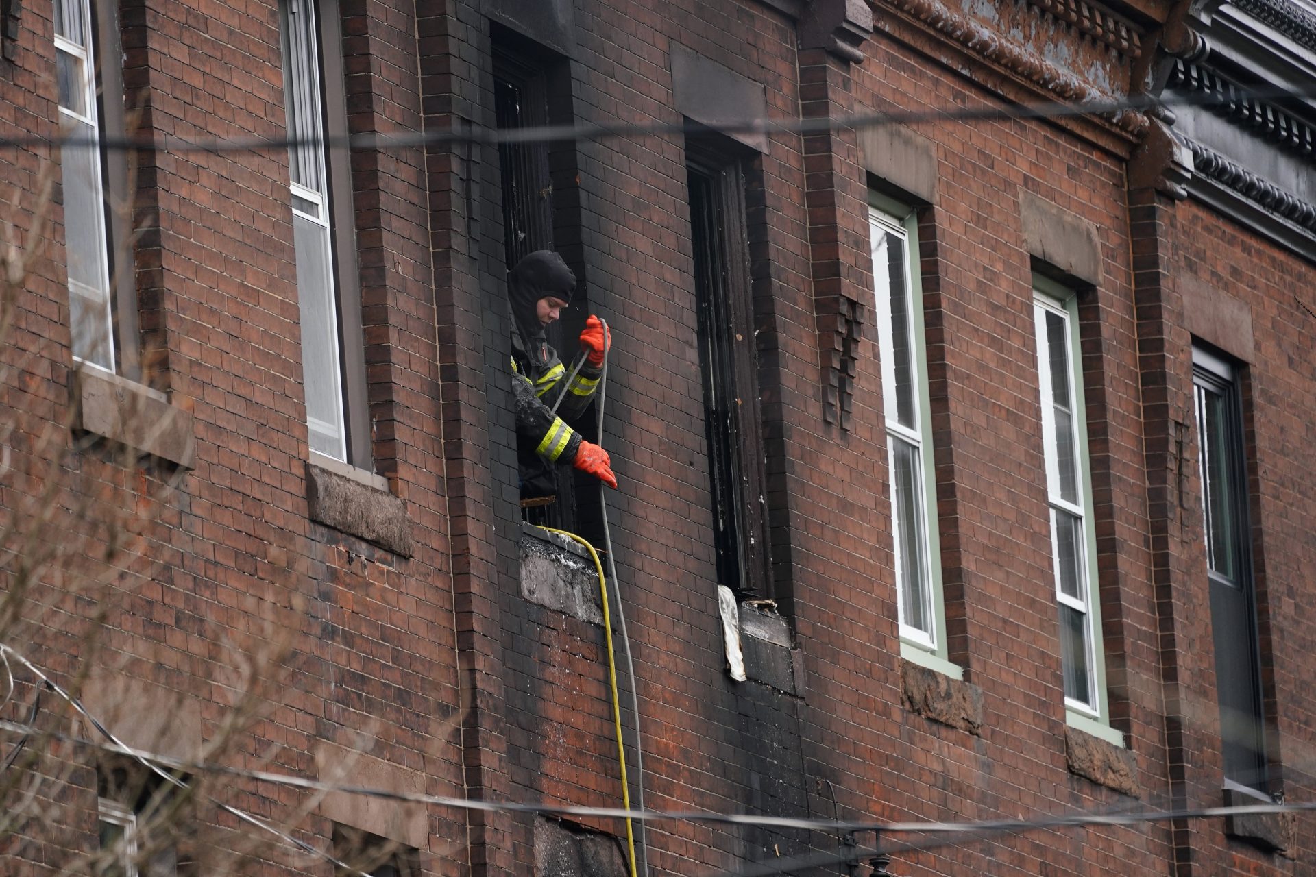 A Philadelphia firefighter works at the scene of a deadly row house fire, Wednesday, Jan. 5, 2022, in the Fairmount neighborhood of Philadelphia.