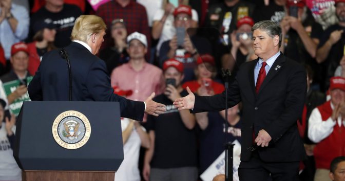 President Donald Trump shakes hands with Fox News Channel's Sean Hannity, right, during a campaign rally Monday, Nov. 5, 2018, in Cape Girardeau, Mo.