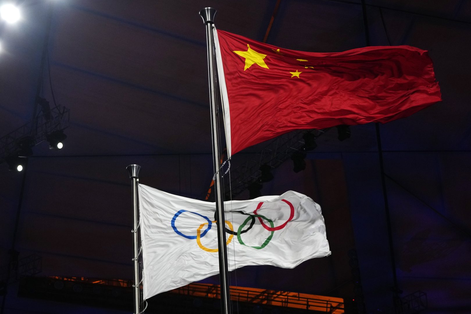 The Chinese and Olympic flags fly during the opening ceremony of the 2022 Winter Olympics, Friday, Feb. 4, 2022, in Beijing. (AP Photo/Natacha Pisarenko)