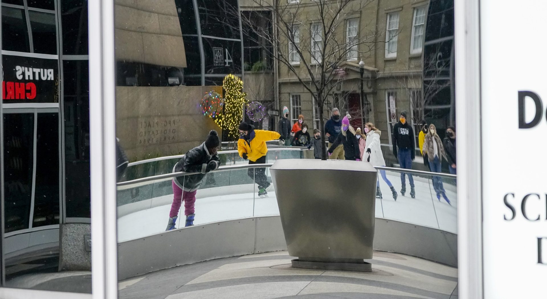 People using the Rink at PPG Place are reflected in glass panels of the surrounding buildings as they skate in mid 30's temperatures, Sunday, Jan. 17, 2021, in Pittsburgh.