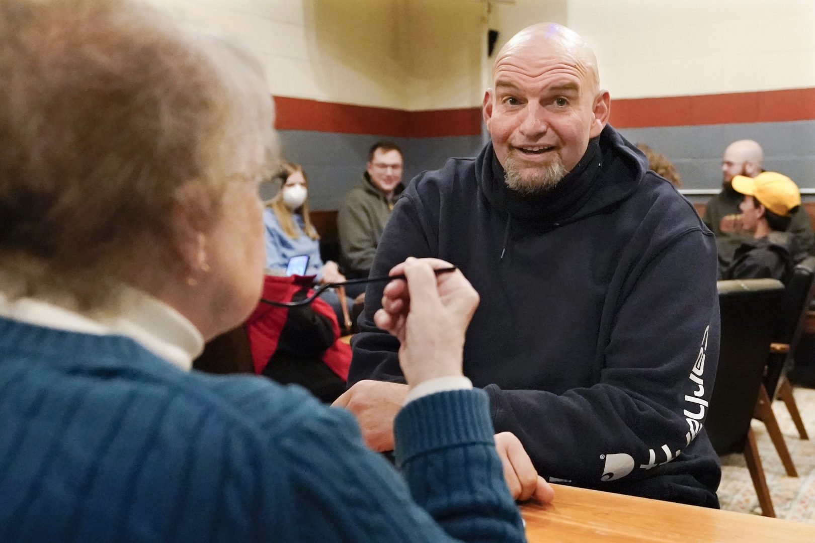 Democratic candidate for the Pennsylvania U.S.senate seat in the 2022 primary election, Lt. Gov. John Fetterman, right, talks with Elisabeth Fulmer during a campaign stop at the Mechanistic Brewery, in Clarion, Pa., Saturday, Feb. 12, 2022. (