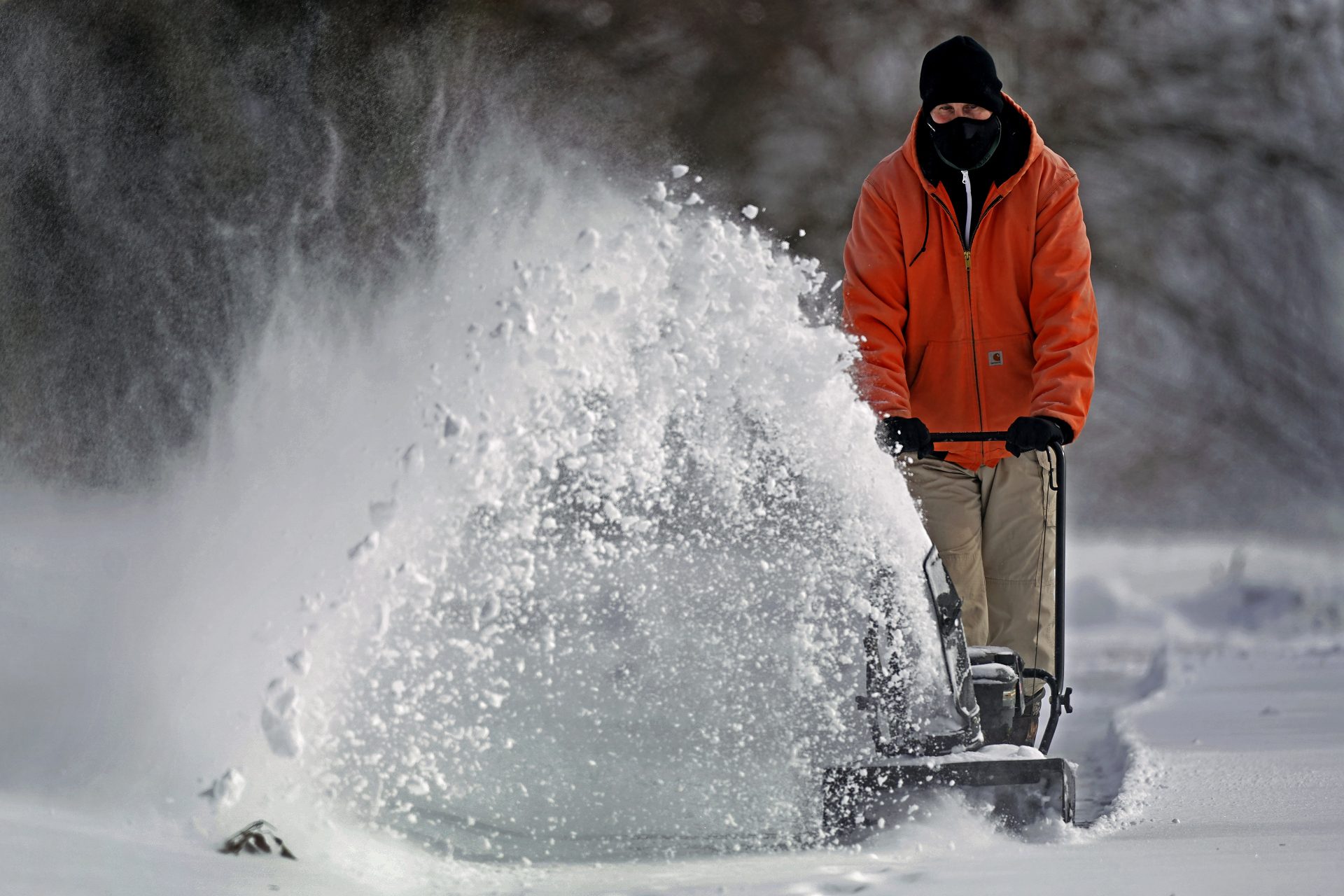 John Tapko clears snow at his house Wednesday, Feb. 2, 2022, in Overland Park, Kan.