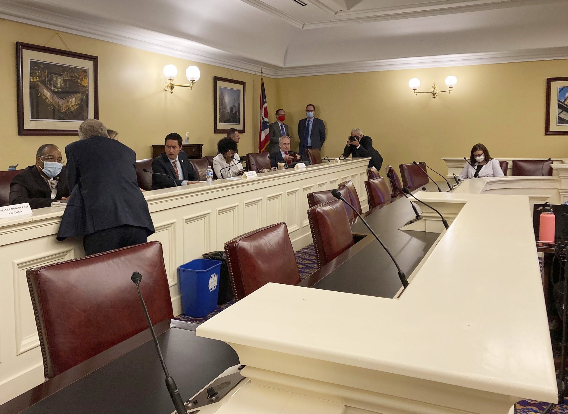 In this Sept. 15, 2021, photo, Republican Ohio Gov. Mike DeWine, foreground, speaks to state Sen. Vernon Sykes, seated, the co-chair of the Ohio Redistricting Commission, as other members of the panel prepare for a meeting on at the Ohio Statehouse in Columbus, Ohio.